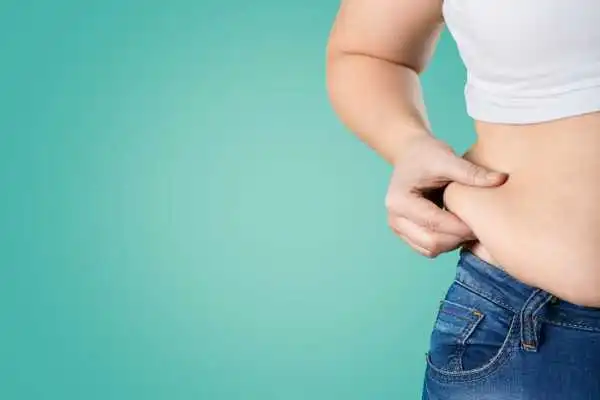 Image of woman pinching her love handles to show weight gain Langley