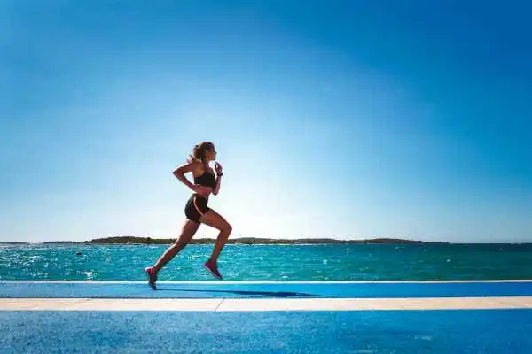 Woman running showing strong leg muscle Langley